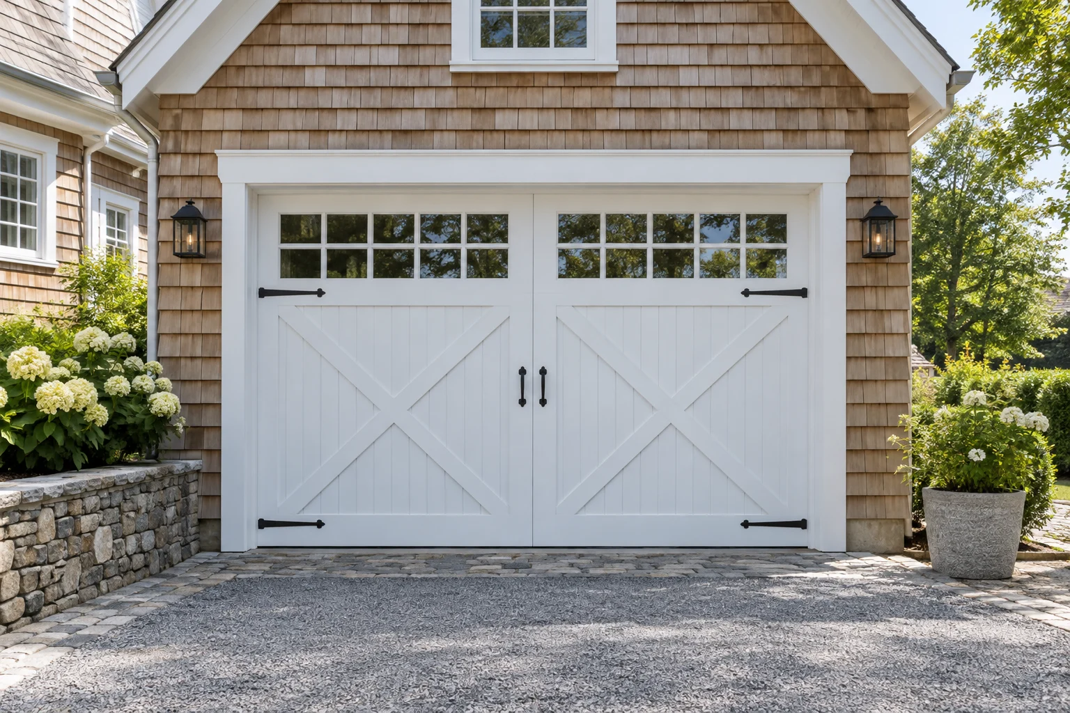 White crossbuck carriage-house garage door with black hinges on a shingle cottage