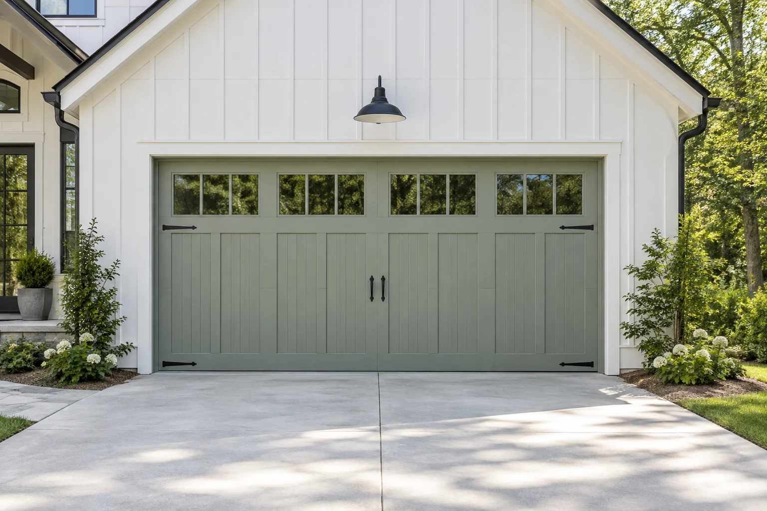 Pale sage carriage-house garage door on a white farmhouse