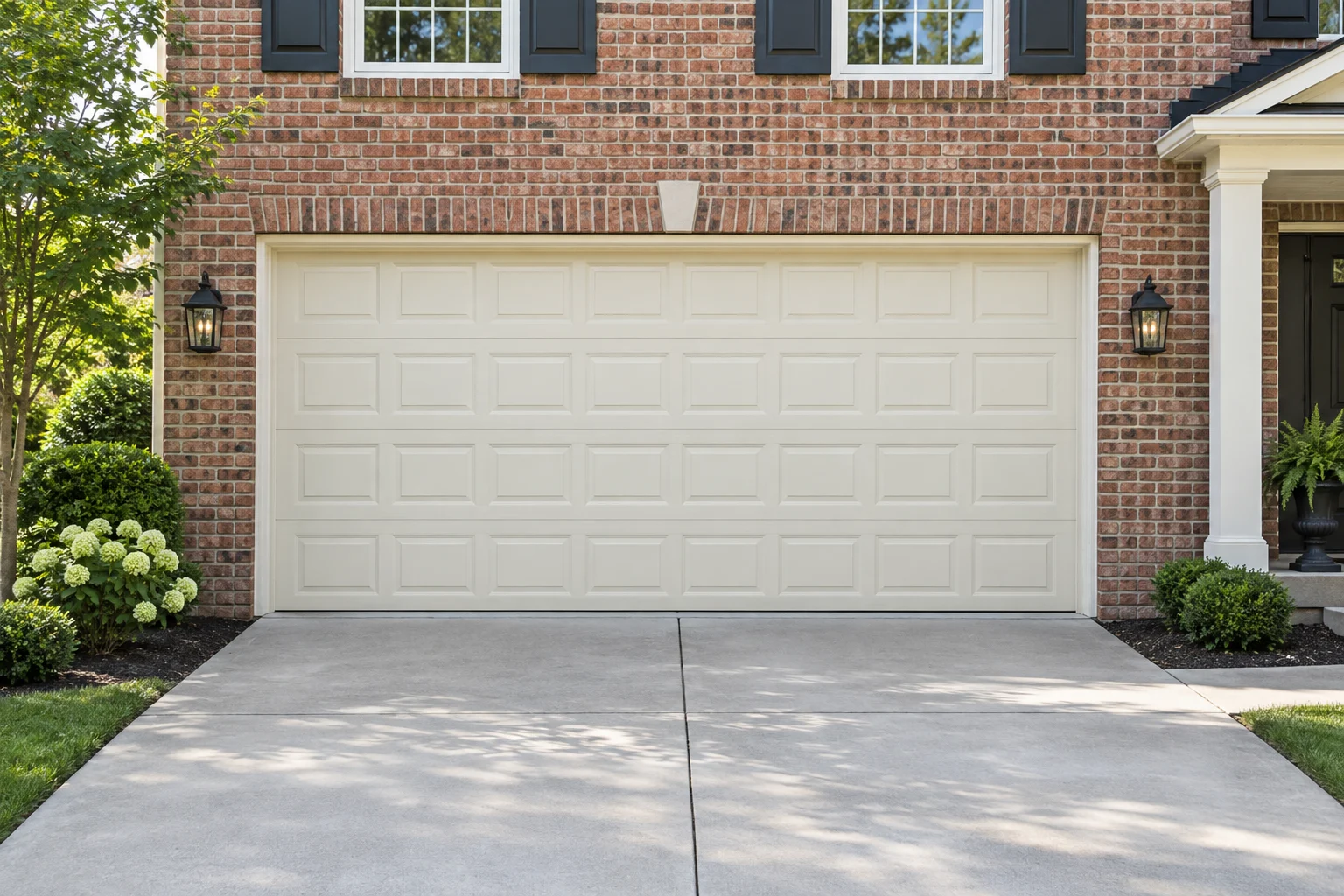 Ivory recessed-panel steel garage door on a brick colonial home in daylight